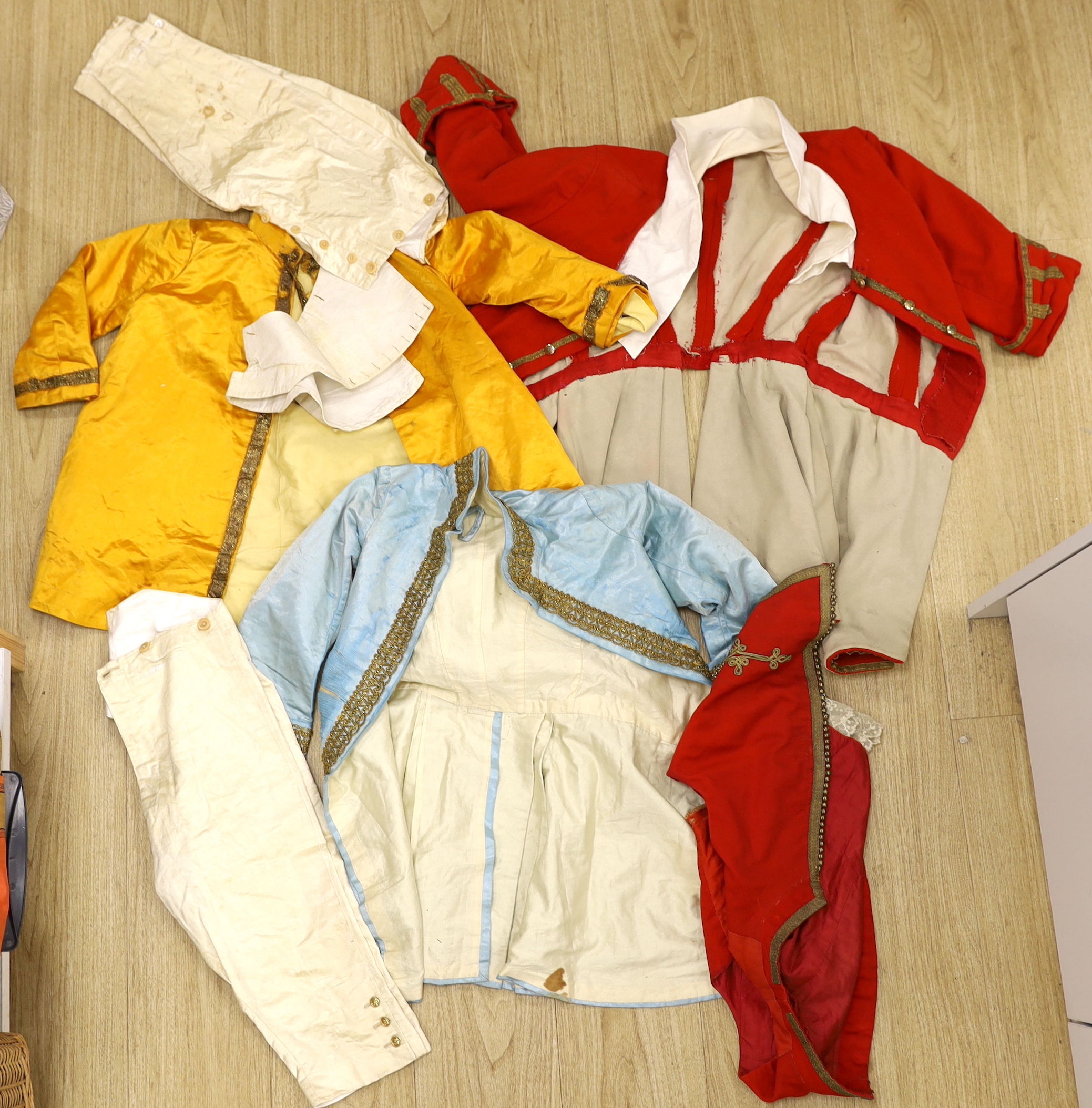 A red wool and gold braided gentleman's jacket with waistcoat, possibly originally military with later alterations, a similar blue satin jacket, etc.